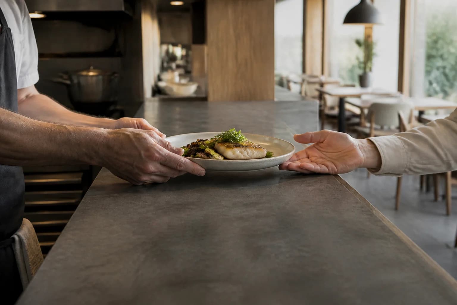 Un plato pasa de las manos de cocina a las de sala.
