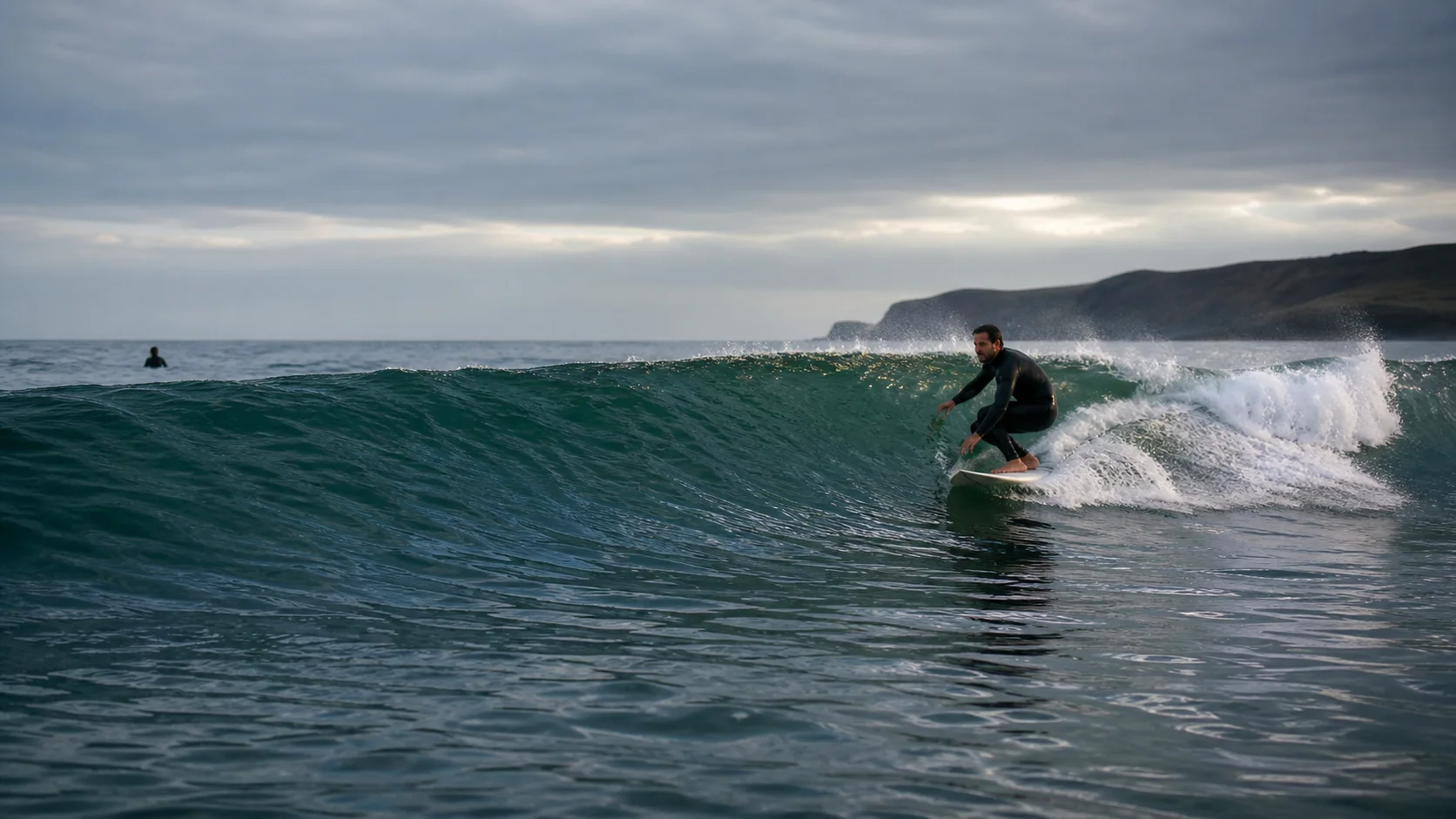 Un surfista recorre una ola limpia visto desde el agua.